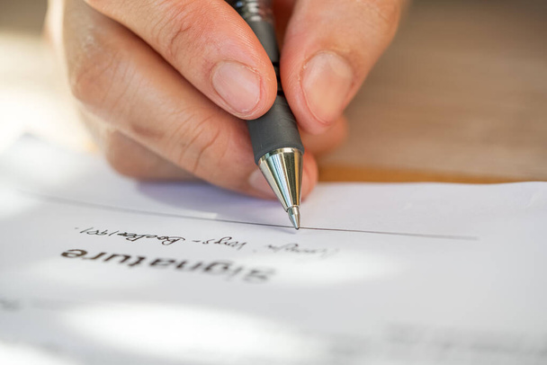 zbliżenie ręki przedsiębiorcy trzymającego długopis do podpisania dokumentu zamówienia - Zdjęcie, obraz