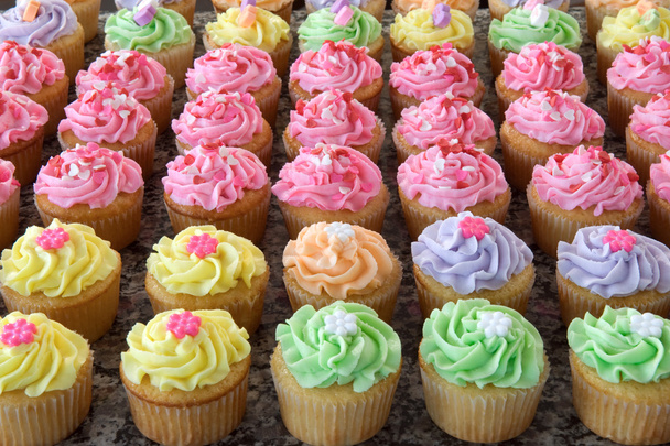 rijen van vele pastel gekleurde cupcakes - Foto, afbeelding