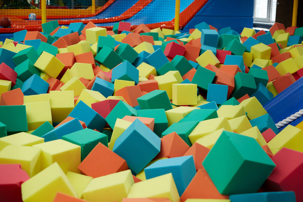 Cubes mous colorés remplissent la piscine sèche pour le saut des enfants. - Photo, image