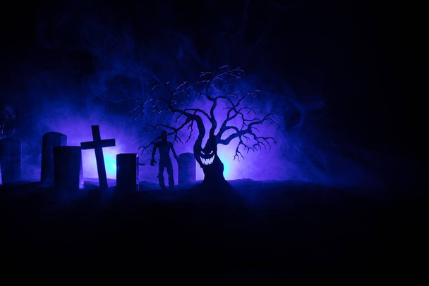 Przerażający widok zombie na cmentarzu martwe drzewo, księżyc, kościół i upiorne zachmurzone niebo z mgłą, koncepcja Horror Halloween. Skupienie selektywne - Zdjęcie, obraz