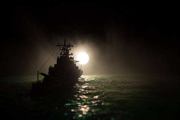 Σχέδιο πολέμου. Σκηνή νυχτερινής μάχης στη θάλασσα. Δραματικό φεγγάρι διακοσμημένο αποτέλεσμα. Η σιλουέτα του πολεμικού πλοίου τη νύχτα. Μικρογραφία δημιουργική διακόσμηση τραπέζι. Επιλεκτική εστίαση - Φωτογραφία, εικόνα