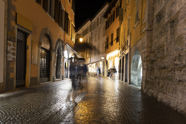 Nocna scena uliczna w Riva del Garda po deszczu - Zdjęcie, obraz