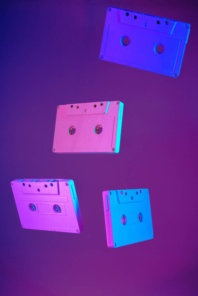 Cassette tape vintage style suspended in air on purple background - Foto, Bild