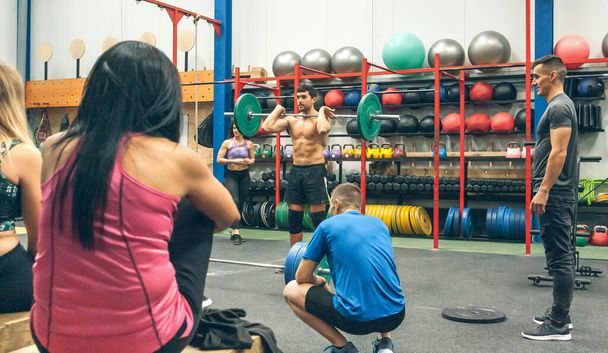Az edző elmagyarázza a súlyemelést az edzőteremben - Fotó, kép