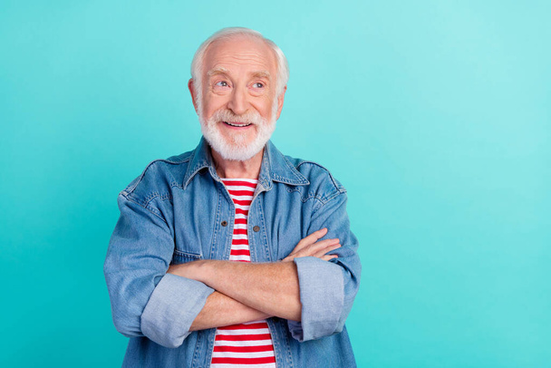 Portrait of attractive cheerful curious grey-haired man folded arms thinking isolated over vivid teal turquoise color background - Фото, изображение