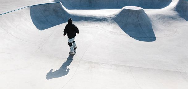 Skateboarding outdoor. Skater skating in an urban concrete skatepark - Photo, Image