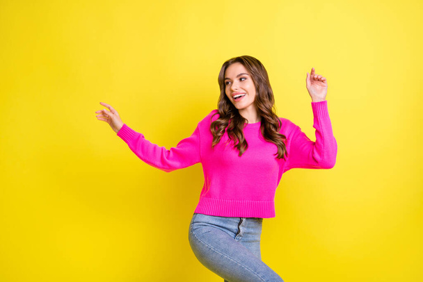 Photo of cute adorable wavy young woman wear pink sweater dancing looking empty space isolated yellow color background - Φωτογραφία, εικόνα