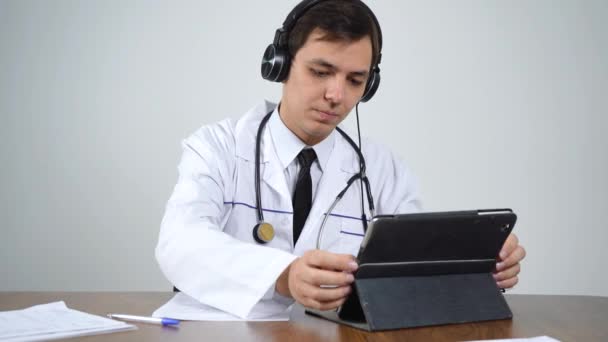 lekarz rozmawia przez łącze wideo z pacjentami za pośrednictwem tabletki - Materiał filmowy, wideo
