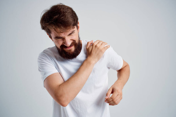 brodaty mężczyzna w białej koszulce lek na stres ból w leczeniu studio szyi - Zdjęcie, obraz
