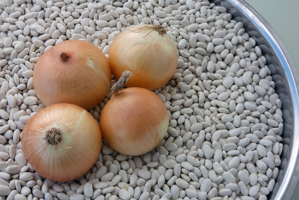 άσπρα φασόλια και τρία κρεμμύδια σε ένα μπολ, - Φωτογραφία, εικόνα