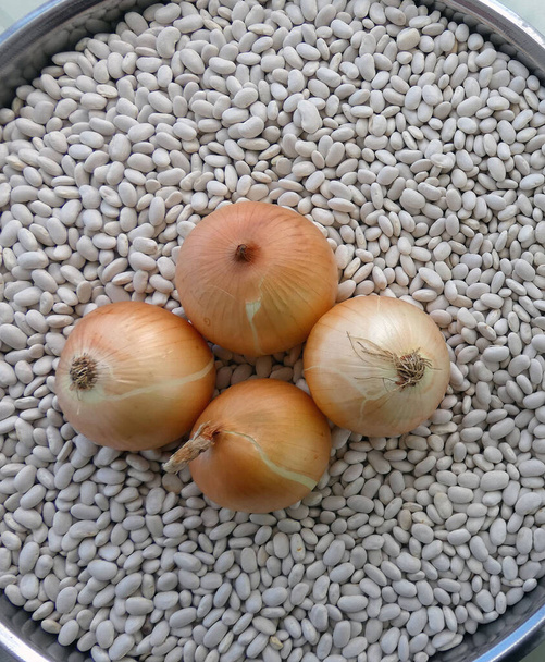 άσπρα φασόλια και τρία κρεμμύδια σε ένα μπολ, - Φωτογραφία, εικόνα