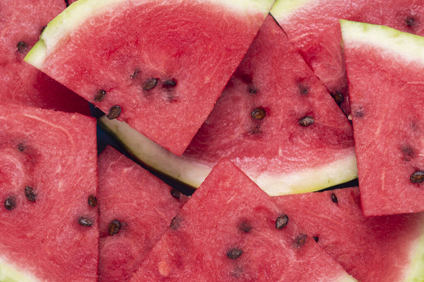 Background of slices of juicy red watermelon. Top view, flat lay. - Zdjęcie, obraz