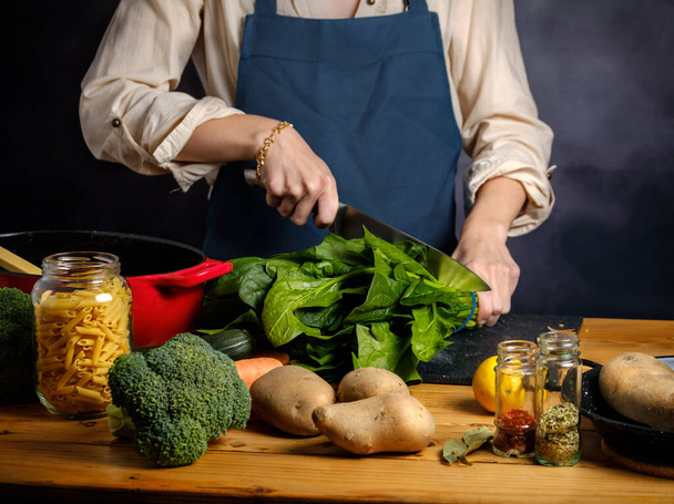 Žena je řezání špenát na kuchyňské desce - Fotografie, Obrázek