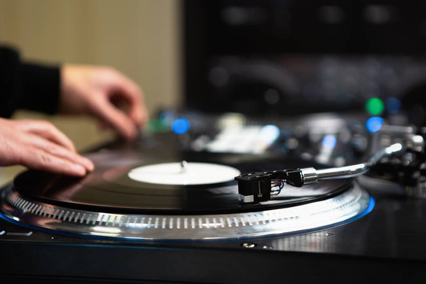 Dj scratching vinyl records on turn table. Professional hip hop disc jockey mixing musical tracks on party - Photo, Image