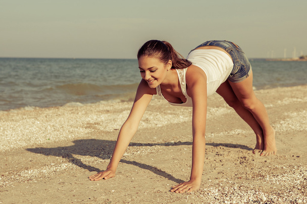 giovane donna che pratica yoga o fitness in riva al mare
 - Foto, immagini