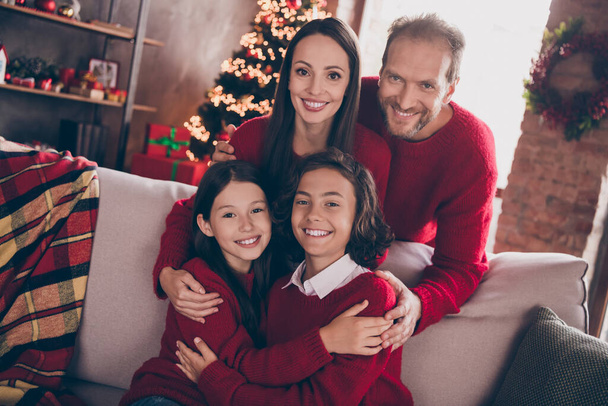 Photo of full family cuddle relax sit on couch wear red jumpers indoors at x-mas - Fotoğraf, Görsel