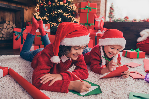 Profile side photo of little kid brother sister lying floor write wish letter to santa claus winter holiday indoors - Φωτογραφία, εικόνα