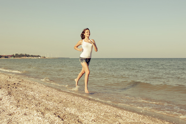 Молодая девушка бежит по морю
 - Фото, изображение