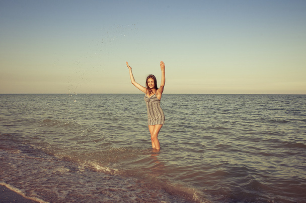 young girl splashing the water in the sea - Foto, imagen