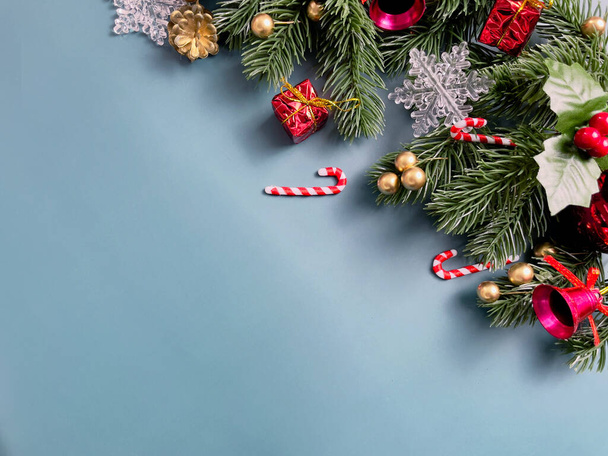 Різдвяні прикраси, листя сосни, золоті кульки, сніжинки, червоні ягоди та золоті ягоди на синьому фоні
 - Фото, зображення