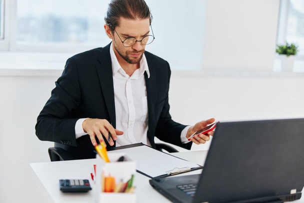 άνθρωπος σε ένα κοστούμι έγγραφα εργασίας γραφείο laptop εκτελεστικό - Φωτογραφία, εικόνα
