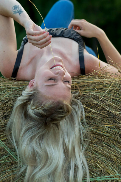 Великолепная блондинка-фермер позирует на свежем воздухе в фермерской обстановке - Фото, изображение