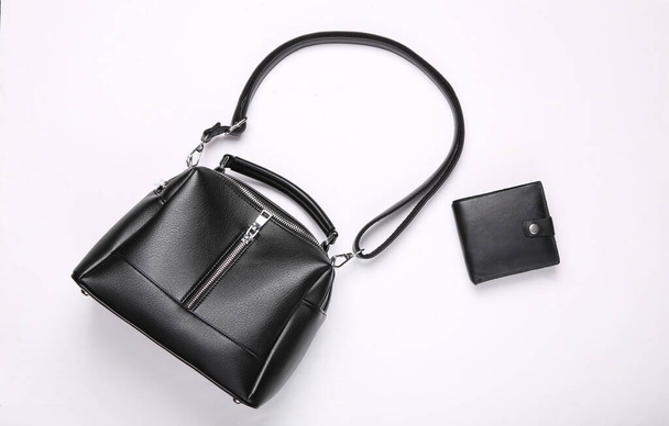 Модная кожаная черная сумка и кошелек на белом фоне. Вид сверху. Плоский лежал - Фото, изображение