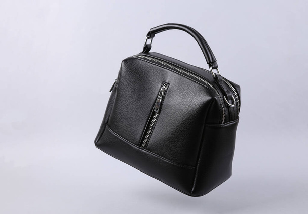 Classic black leather bag levitating on gray background - Photo, Image
