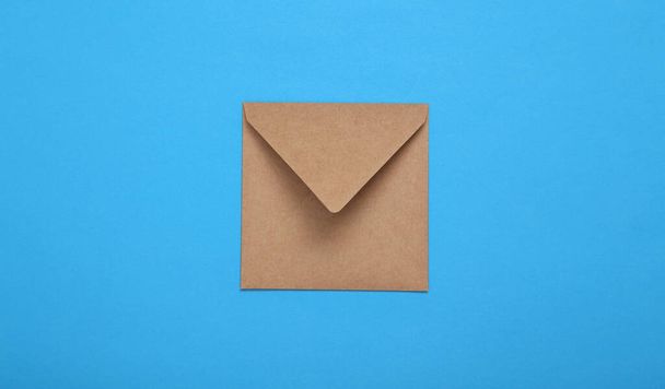 Craft envelope on blue background. Top view - Photo, Image