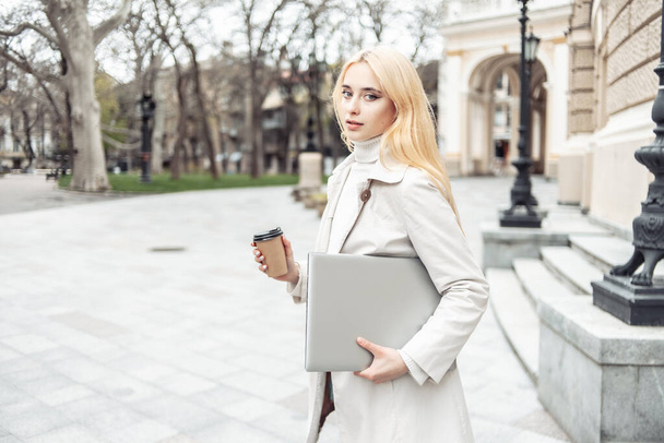 Junge Studentin mit Laptop und Tasse Kaffee in der Stadt - Foto, Bild