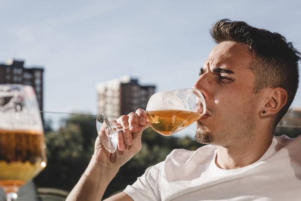 Uomo godendo di un bicchiere di birra in città all'aperto - Foto, immagini