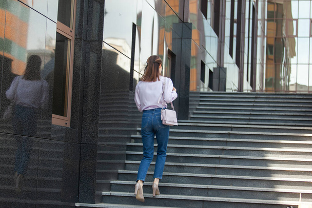 Attractive business woman climbs the stairs. Lifestyle - Фото, изображение