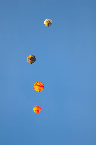 Een kleurrijke heteluchtballon drijft op de vroege ochtend wind op de 2021 Albuquerque NM Ballon Fiesta. - Foto, afbeelding