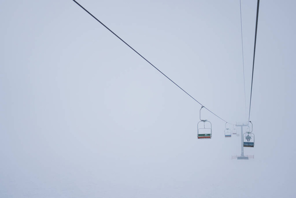 Cable cars hang on cables in a silent fog - Foto, afbeelding