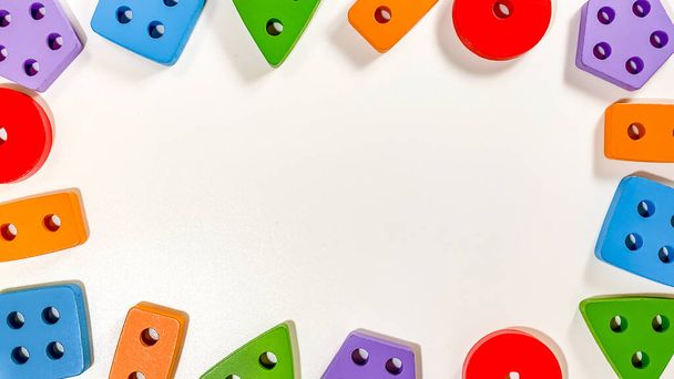 Un diseño de juguetes educativos para niños pequeños en forma de clasificadores multicolores sobre un fondo blanco. Concepto de desarrollo temprano del bebé - Foto, Imagen