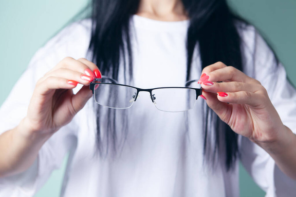young woman holding optical glasses - Фото, изображение