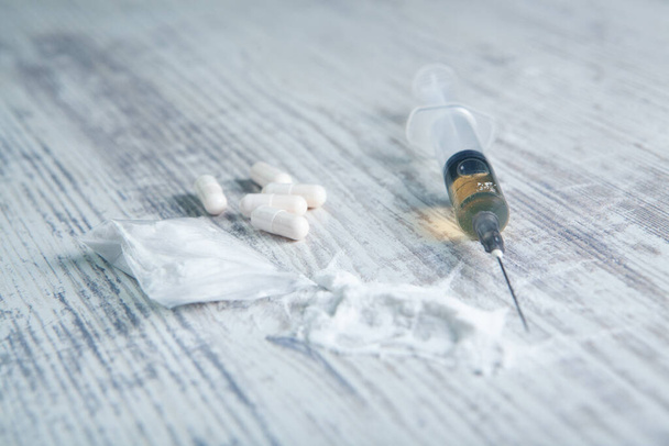 white powder, capsules and syringe on the table - Photo, image