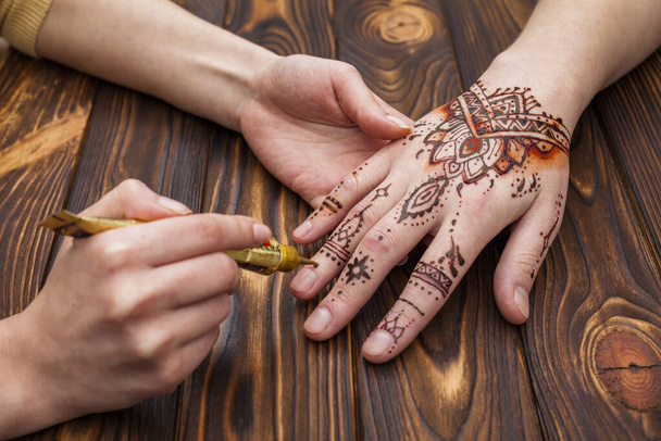 Mehndi nők kezét készítő művész. Kiváló minőségű gyönyörű fotó koncepció - Fotó, kép