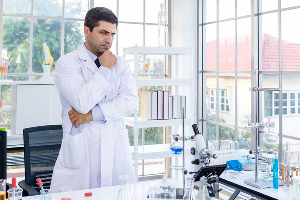 Confident scientist portrait of Happy male scientist keeping arms crossed in a chemistry lab scientist holding test tube with sample in Laboratory analysis background - Fotó, kép