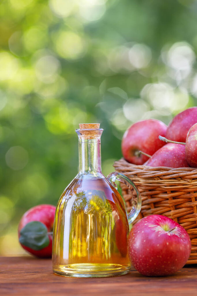apple vinegar or cider in glass bottle outdoors - Фото, зображення