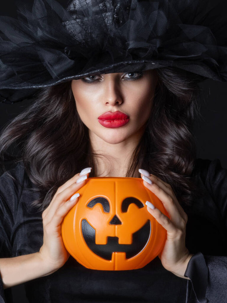 Woman in witch costume hold Halloween pumpkin bucket for candies close up beauty portrait - Zdjęcie, obraz