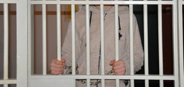 Закритий засуджений чоловік з наручниками за сіткою
 - Фото, зображення