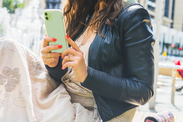 Женщина с мобильным телефоном на улице - Фото, изображение