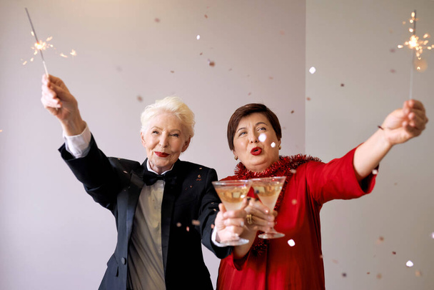 Two beautiful stylish mature senior women celebrating new year. Fun, party, style, celebration concept - Photo, Image