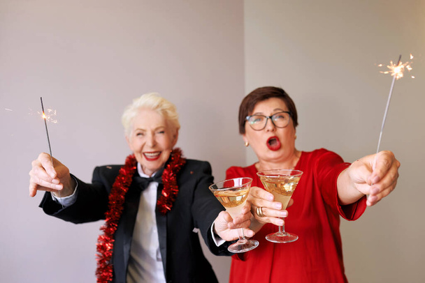 Twee mooie, stijlvolle oudere vrouwen die nieuwjaar vieren. Plezier, feestje, stijl, feestconcept - Foto, afbeelding