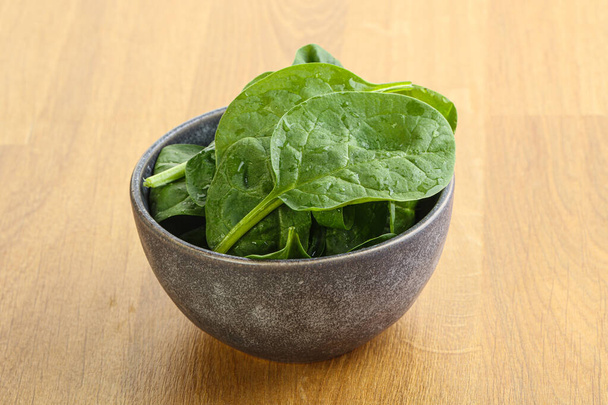 Fresh green spinach leaves in the bowl over wooden background - Fotó, kép