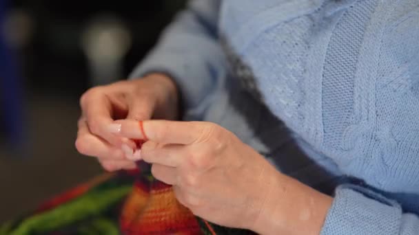 Mani delle donne maglia maglione di colore lana con ferri da maglia. Vista dall'alto, primo piano delle mani e lavoro a maglia - Filmati, video