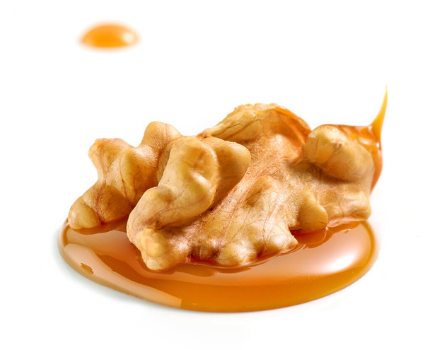 saksanpähkinä sulaneessa karamellissa eristettynä valkoisella pohjalla - Valokuva, kuva