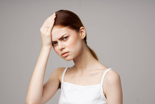 disgruntled woman holding head migraine disorder light background - Foto, immagini