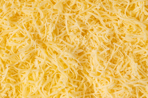 Geraspte kaas achtergrond textuur. gele versnipperde kaas. Close-up bovenaanzicht. - Foto, afbeelding